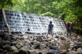 Two young men hike to the base of a waterfall. Royalty Free Stock Photo