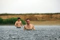 Two young man are in a river under the rain Royalty Free Stock Photo