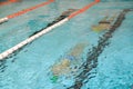 Two young men swimming underwater in a pool. Distorted view of people in the water.