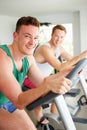 Two Young Men Training In Gym On Cycling Machines Together Royalty Free Stock Photo