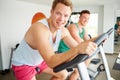 Two Young Men Training In Gym On Cycling Machines Together Royalty Free Stock Photo