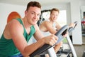 Two Young Men Training In Gym On Cycling Machines Together Royalty Free Stock Photo