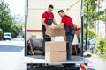 Young Men Stacking The Cardboard Boxes In Moving Truck Royalty Free Stock Photo