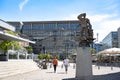 Media Harbor Dusseldorf. Two men strolling on Medienhafen with Immendorff staue `Hans Albers` a singer and actor as sailor Royalty Free Stock Photo