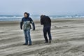 Two young men on a windy beach