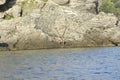 Two young meng fishing at the edge of a rocky mountain near to mediterranean sea at sicily italian island