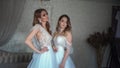 Two young models posing in front of the photographer in a wedding dress. Royalty Free Stock Photo