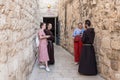 Two young monks stand and talk with two young girls near the entrance to Grotto of Gethsemane on foot of the mountain Mount Eleon