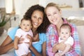 Two Young Mothers On Sofa At Home