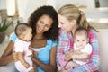 Two Young Mothers On Sofa At Home Royalty Free Stock Photo