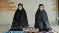 Two young Muslim women are performing prayers. Islamic religion,part 2