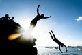 Two young natives, in silhouette, are jumping from the Porto da Barra pier in the city of Salvador, Bahia