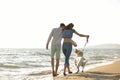 Two young people running on the beach kissing and holding tight with dog Royalty Free Stock Photo