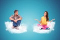 Two young people sitting on clouds welcoming Royalty Free Stock Photo