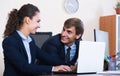 Two young managers using laptop at work