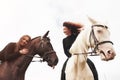 Two young pretty girls riding a horses on a field. They loves animals andhorseback riding Royalty Free Stock Photo