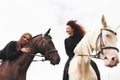 Two young pretty girls riding a horses on a field. They loves animals andhorseback riding Royalty Free Stock Photo