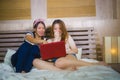 Two young pretty and happy Asian Korean student girls together at home bedroom using internet social media in laptop computer Royalty Free Stock Photo