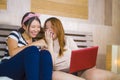 Two young pretty and happy Asian Korean student girls together at home bedroom using internet social media in laptop computer Royalty Free Stock Photo