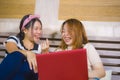 Two young pretty and happy Asian Korean student girls together at home bedroom using internet social media in laptop computer Royalty Free Stock Photo