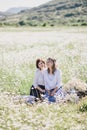 Two young pretty women having picnic with tea in chamomile field Royalty Free Stock Photo