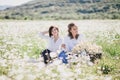 Two young pretty women having picnic with tea in chamomile field Royalty Free Stock Photo