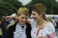 Two young pretty women in Soviet Red Army soldier side caps laughing and communicating, celebrating the Victory Day Royalty Free Stock Photo