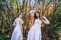 Two young princess wearing nice beige dress in autumn park. Fashion photo