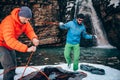 Two young professional male tourists are preparing to camp in the mountains near the river in winter.