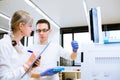 Two young researchers carrying out experiments in a lab