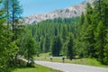 Two young road cyclists ride along the scenic freeway in the sunny French Alps.