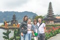 Two Young romantic couple of trourists on the Ulan Danu temple background. Bali island.