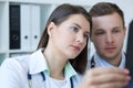 Two young serious confident doctors checking the x-ray of their patient and making a diagnosis. Radiologist or