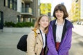 Two young sisters having fun outdoors on sunny spring day. Kids on their way to school