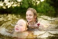 Two young sisters having fun on a sandy lake beach on warm and sunny summer day. Kids playing by the river Royalty Free Stock Photo