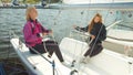 Two young sisters of a sailing sportswoman are preparing for a multi-day regatta on a sports yacht. Lay out the gear and Royalty Free Stock Photo