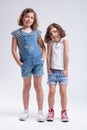 Two young sisters standing with hands in pockets