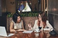 Two young smiling caucasian businesswomen with laptop. Women in cafe Royalty Free Stock Photo