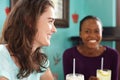 Two young smiling women at cafe