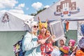 Two young smiling women trying on comical original felted wool hats at traditional Irbit fair,Russia