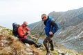 Two young sports men are sitting on top of the mountain with sporting gear Royalty Free Stock Photo