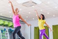 Two young sporty women exercising in fitness studio, dancing, doing cardio, working on balance and coordination. Royalty Free Stock Photo
