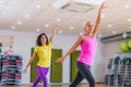 Two young sporty women exercising in fitness studio, dancing, doing cardio, working on balance and coordination. Royalty Free Stock Photo