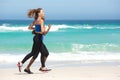 Two young sporty women running on the beach Royalty Free Stock Photo