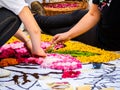 Two young street artists, working on the ground, a colorful design made of flowers