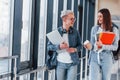 Two young student friends together in a corridor of a college walking together and holding notepad, laptop and cup of Royalty Free Stock Photo