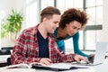 Two young students browsing internet for online useful information