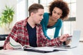 Two young students browsing internet for online useful information