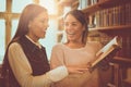 Two young students girls at library reading book Royalty Free Stock Photo