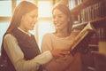 Two young students girls reading book in library. Royalty Free Stock Photo